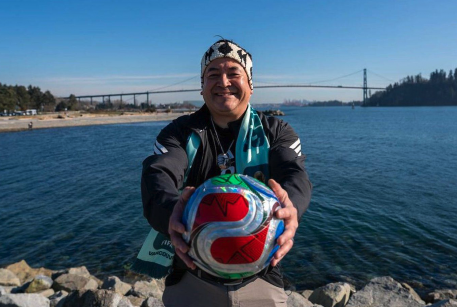 <who> Photo credit: Sam Falk </who> Squamish Nation chairperson Sxwíxwtn (Wilson Williams) holds a soccer ball as he gears up for the FIFA World Cup.